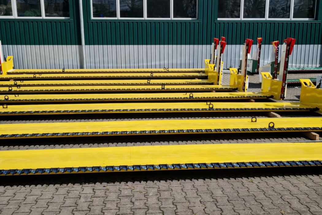 Декілька жовтих ріпакових столів MAANS-R 7500 на фоні будівлі підприємства